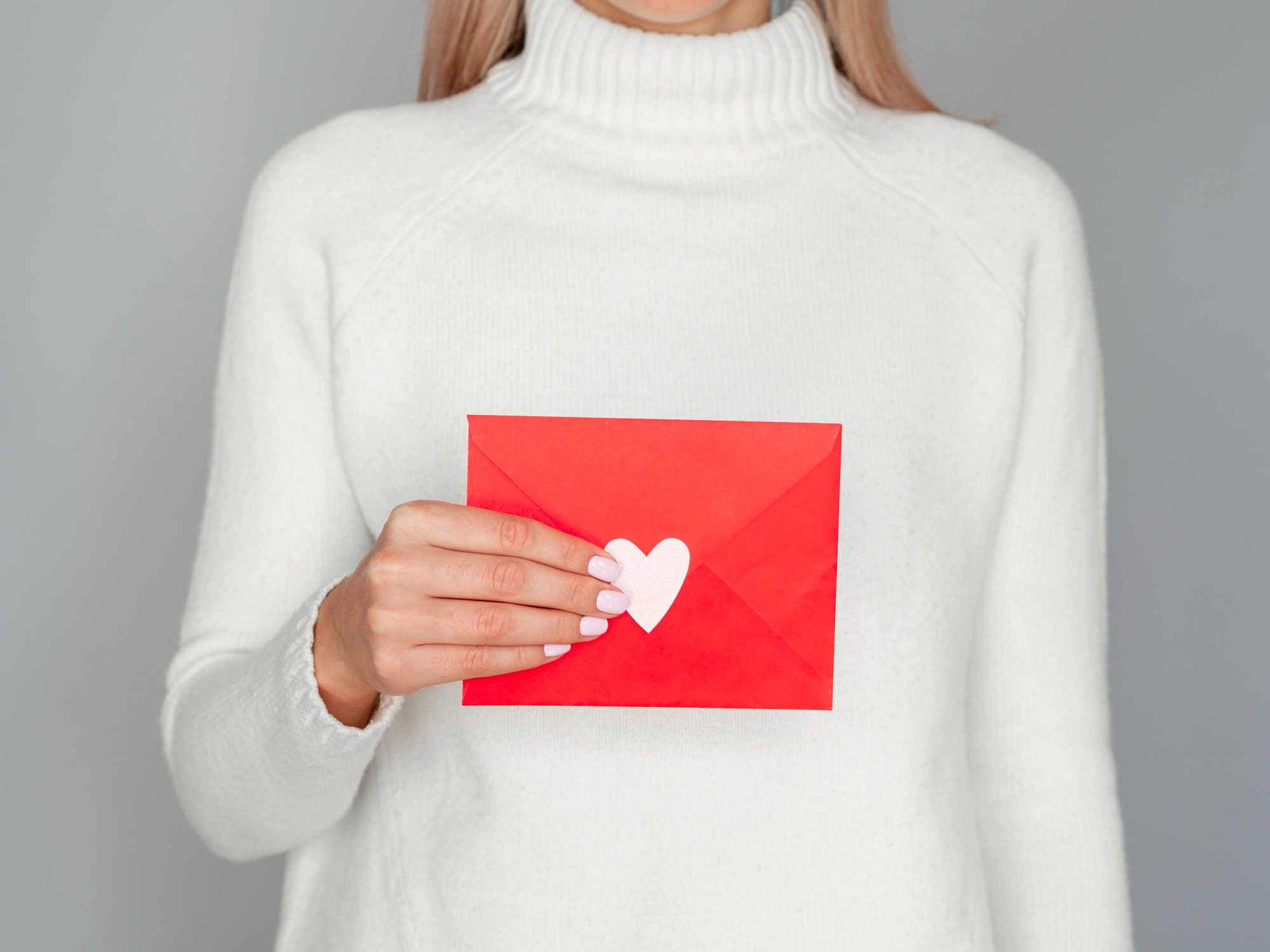 A woman holding an envelope | Source: Freepik