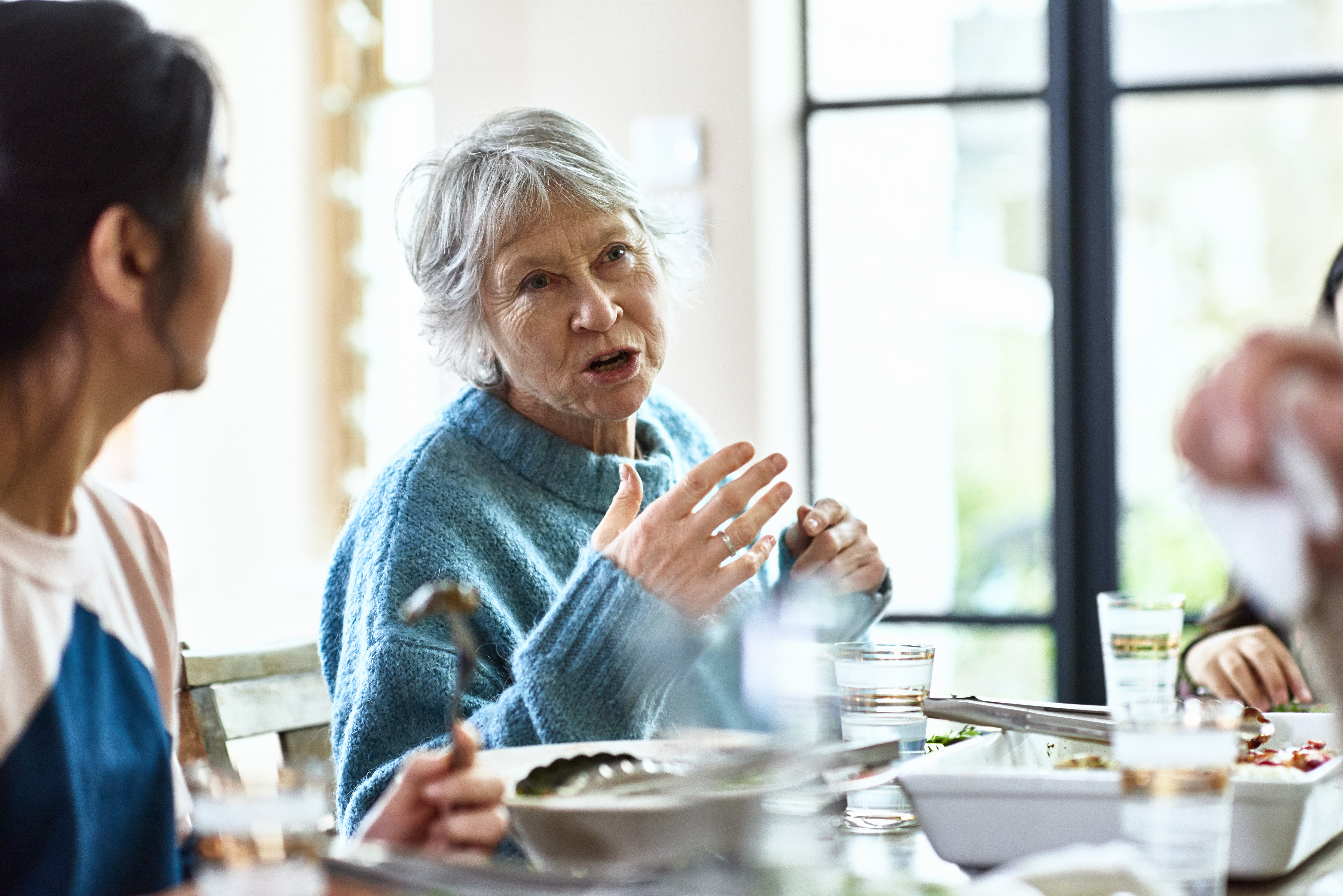 A grandmother telling stories at the dinner table | Source: Getty Images