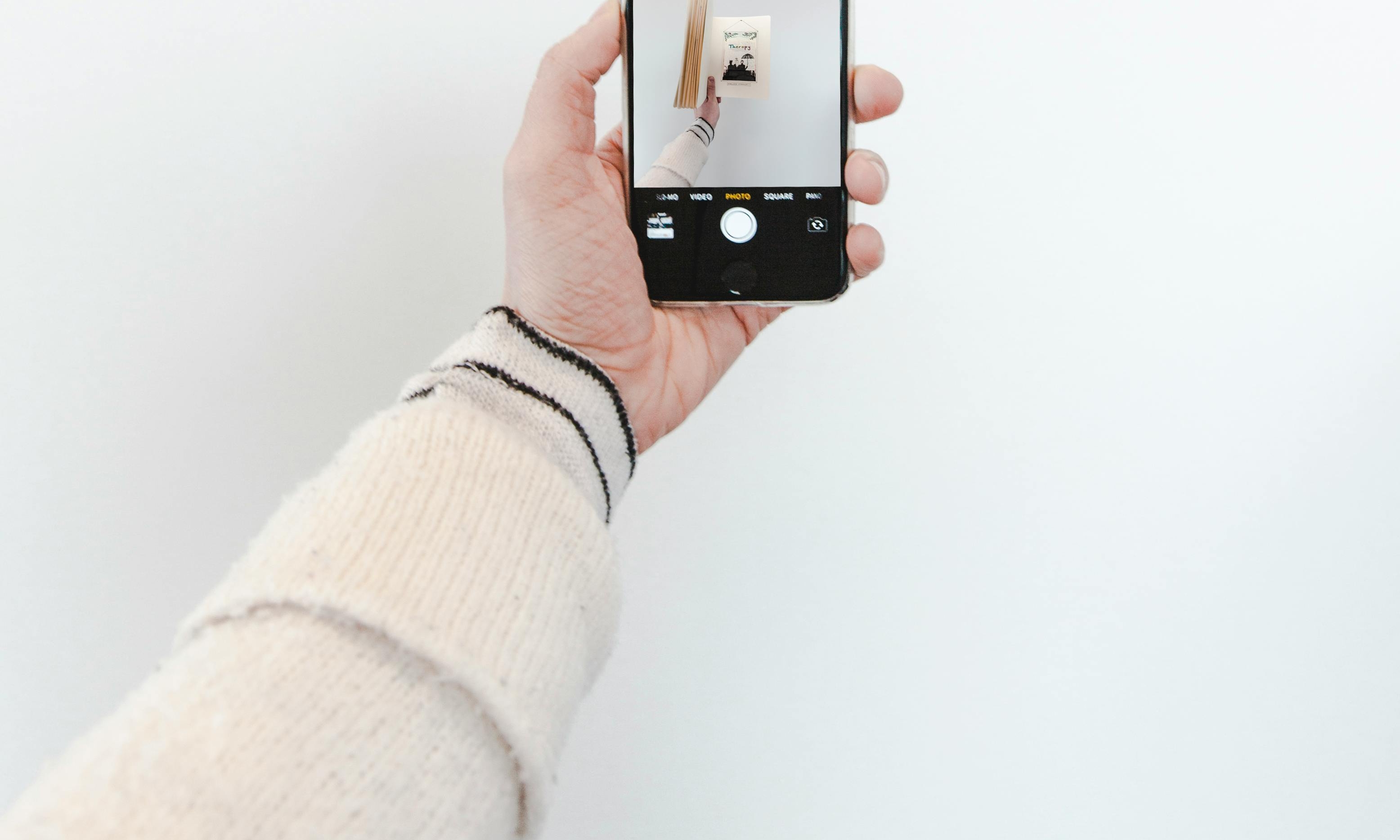 Amy taking photos of the poster with her phone | Source: Pexels